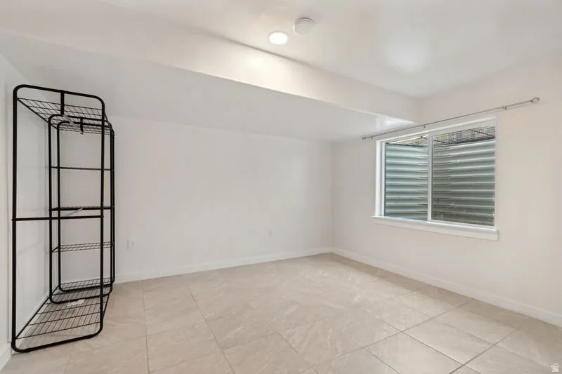 Spacious room featuring light-toned tile flooring and white painted walls