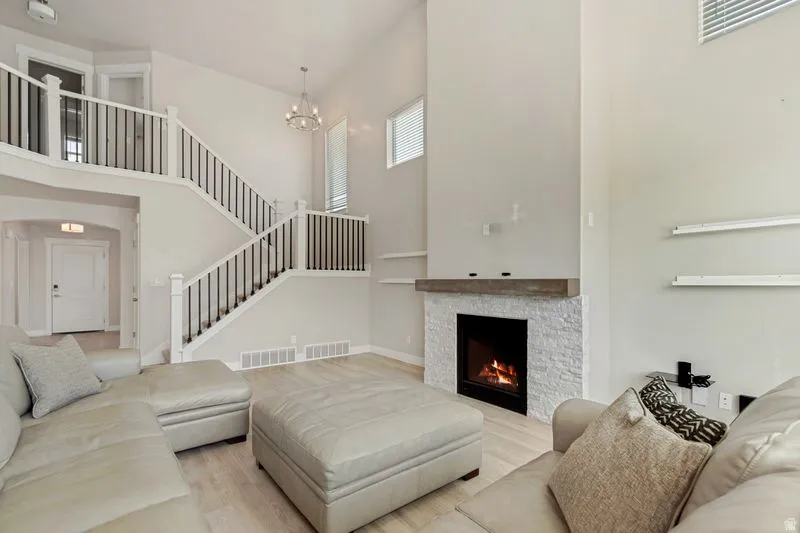 Soaring two-story living room anchored by a striking gas fireplace with marble surround and modern mantel