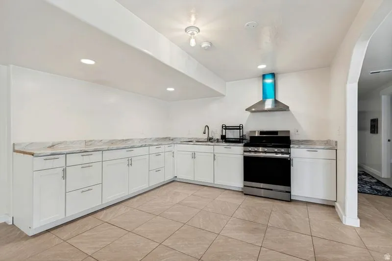 Spacious kitchen featuring white cabinetry, light-toned countertops, and tile flooring