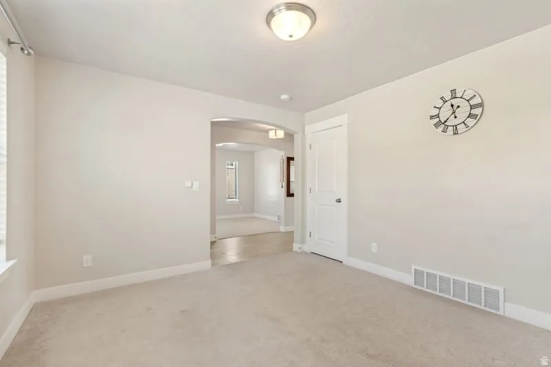 Carpeted room with light neutral walls, white trim, and a semi-flush mount ceiling light