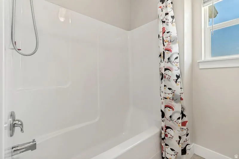White fiberglass tub and shower combination with chrome fixtures