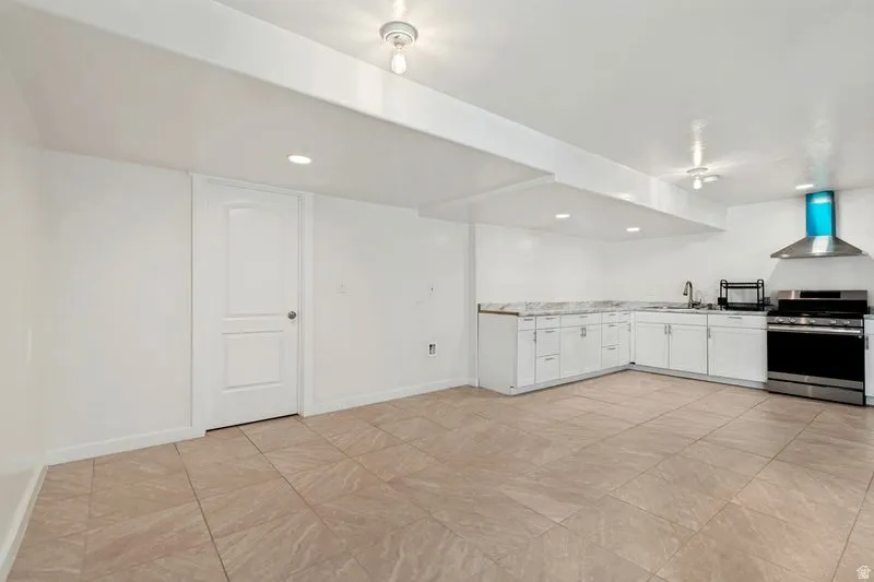 Spacious room featuring neutral tile flooring and recessed lighting