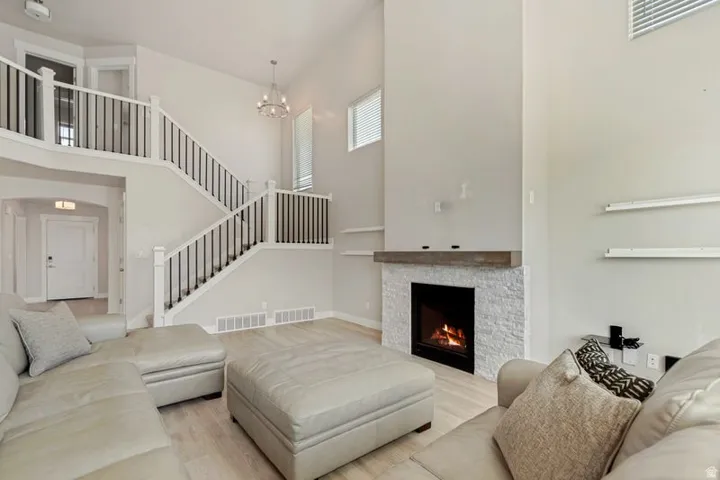 Soaring two-story living room anchored by a striking gas fireplace with marble surround and modern mantel