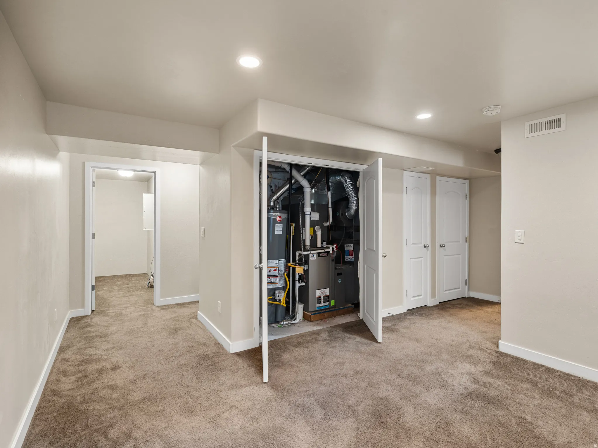 Interior space featuring light beige walls and neutral tone carpeting