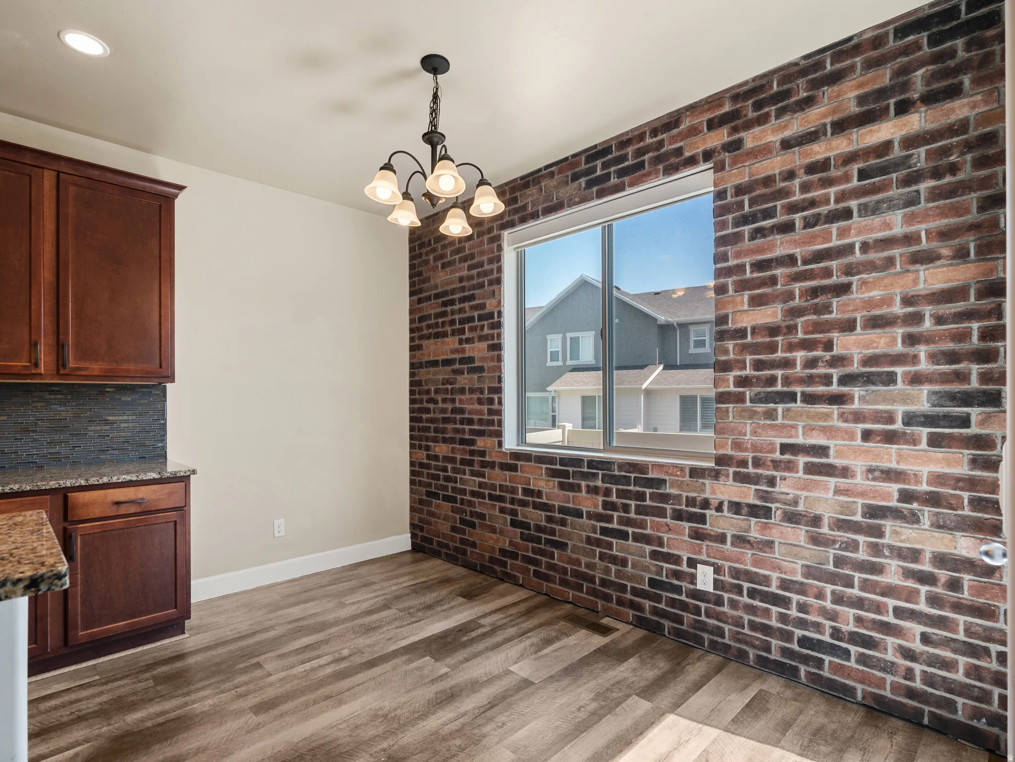 Dining area featuring a prominent exposed brick accent wall
