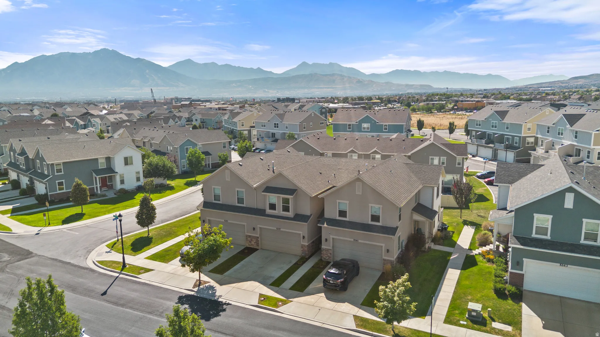 Modern townhomes featuring stucco and siding exteriors, attached two-car garages, and landscaped front yards