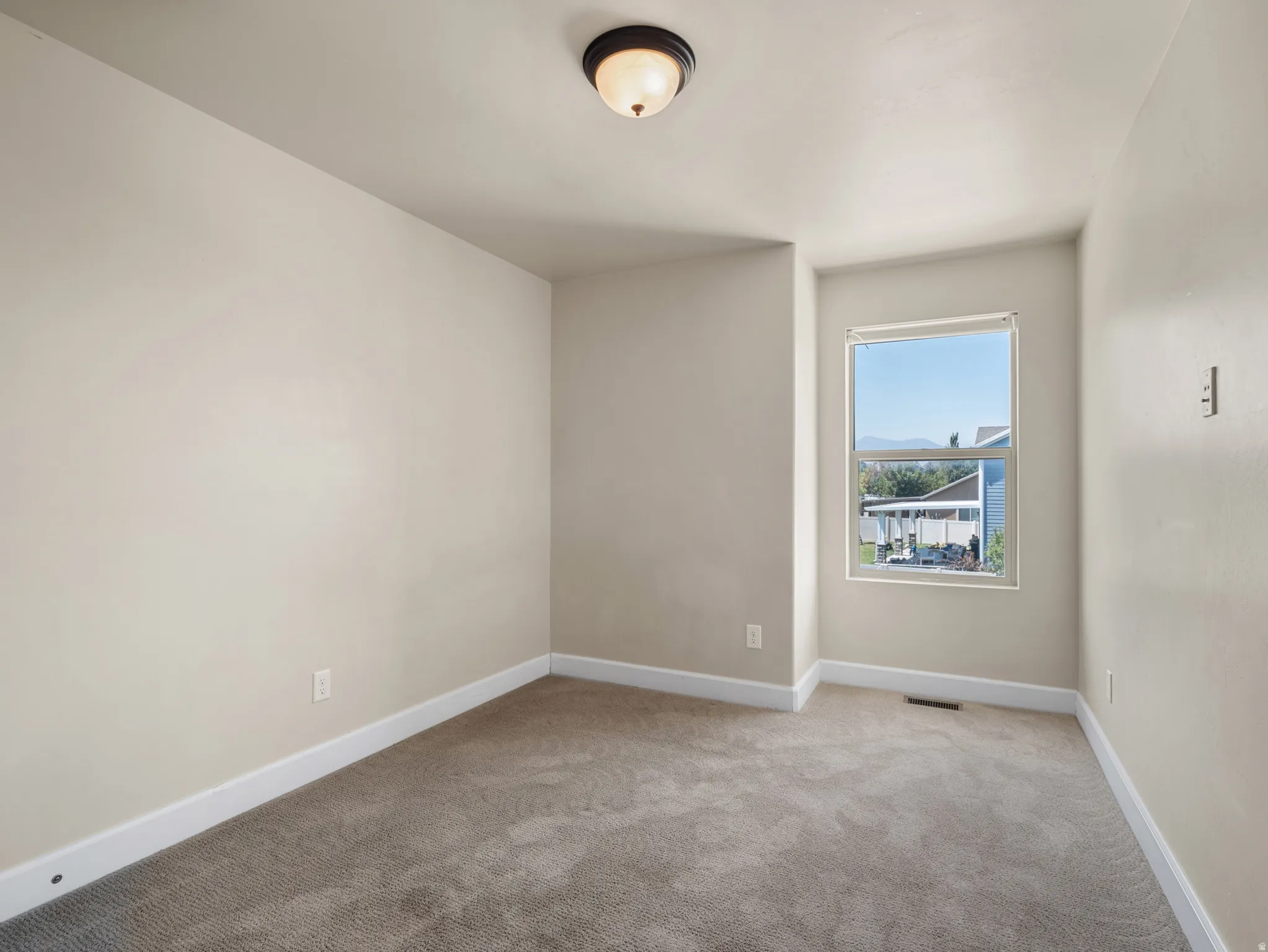 Neutral-toned walls complement the plush carpet flooring