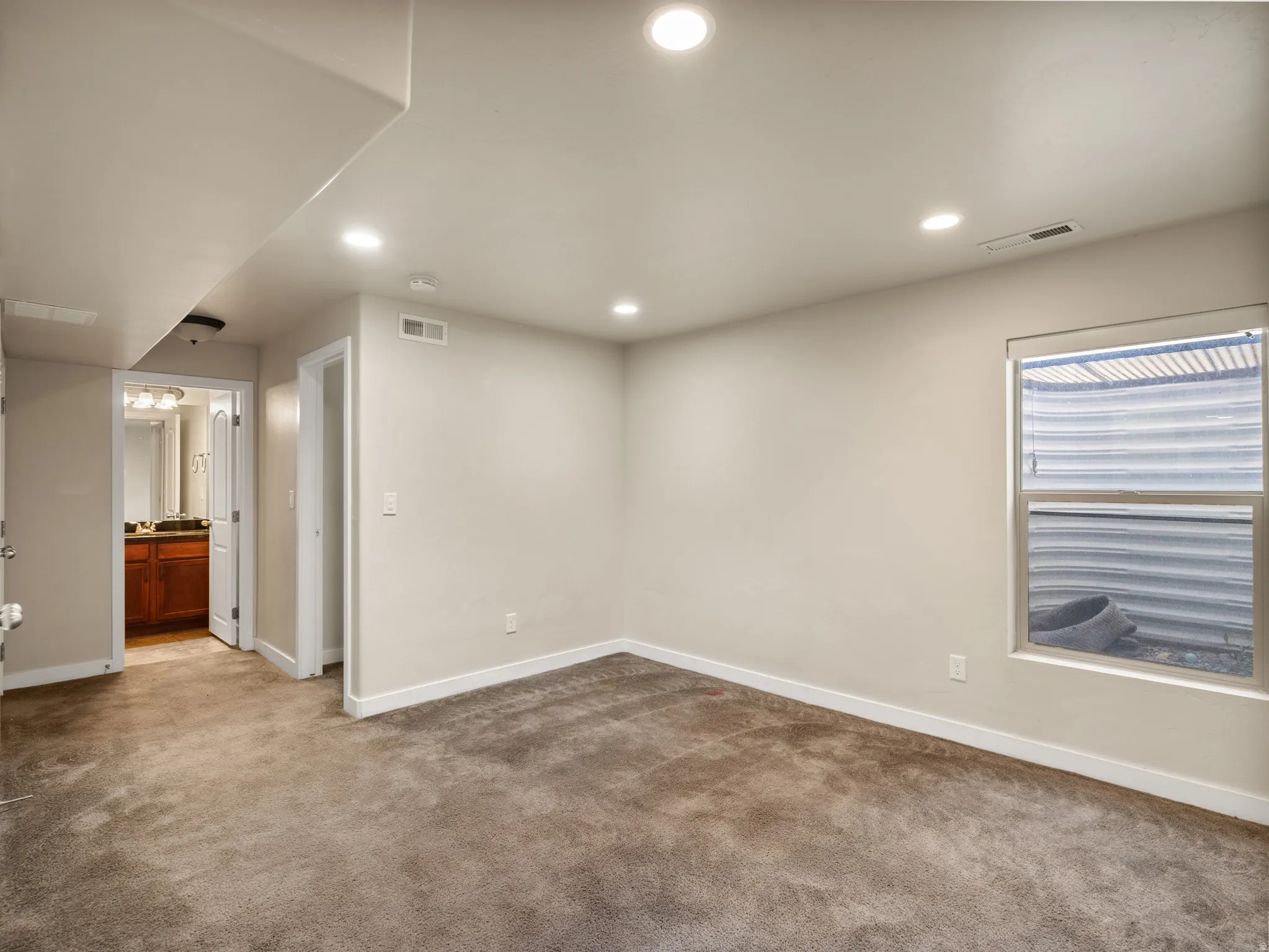 Carpeted room with recessed lighting, light-toned walls, and white trim