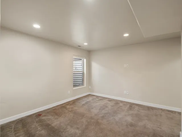 Neutral-toned wall finishes with recessed lighting and carpet flooring
