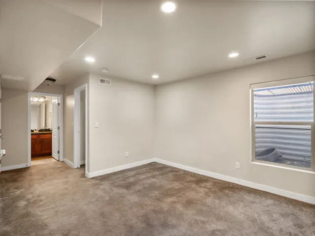 Carpeted room with recessed lighting, light-toned walls, and white trim