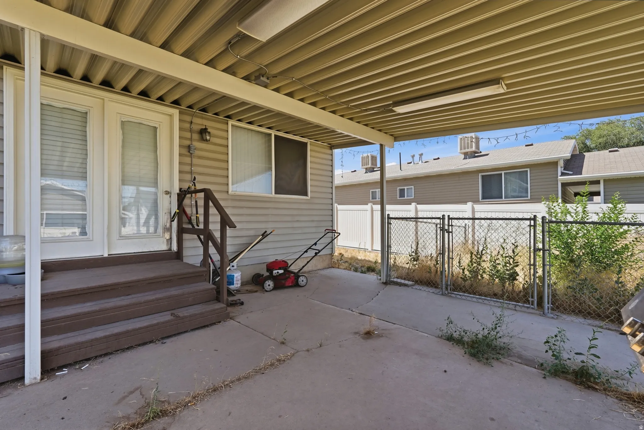Covered patio with metal roof and stepped entry featuring durable concrete flooring