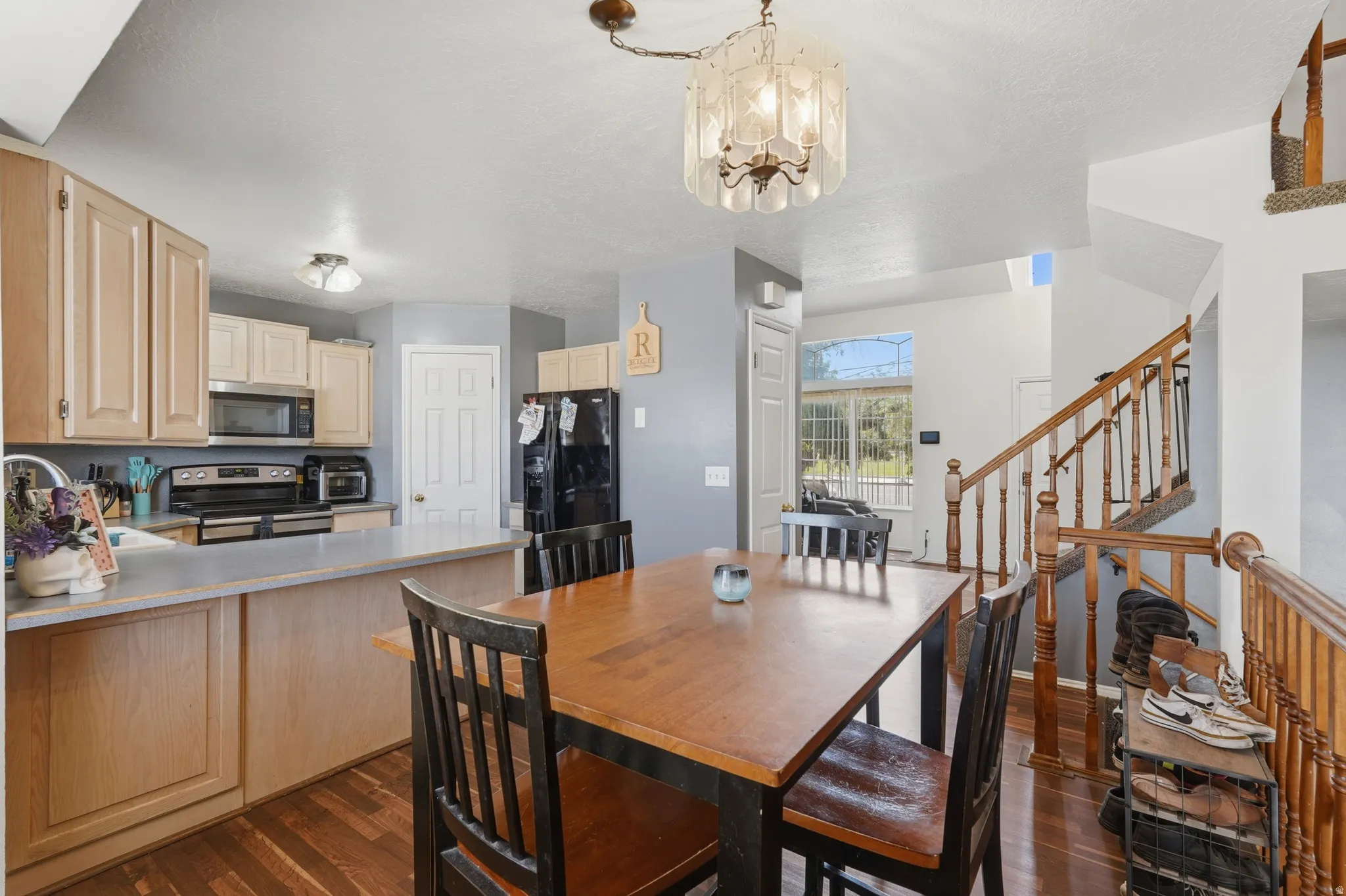 Open-concept kitchen and dining area featuring wood-finish flooring, light-toned cabinetry, and a kitchen island with integrated counter space