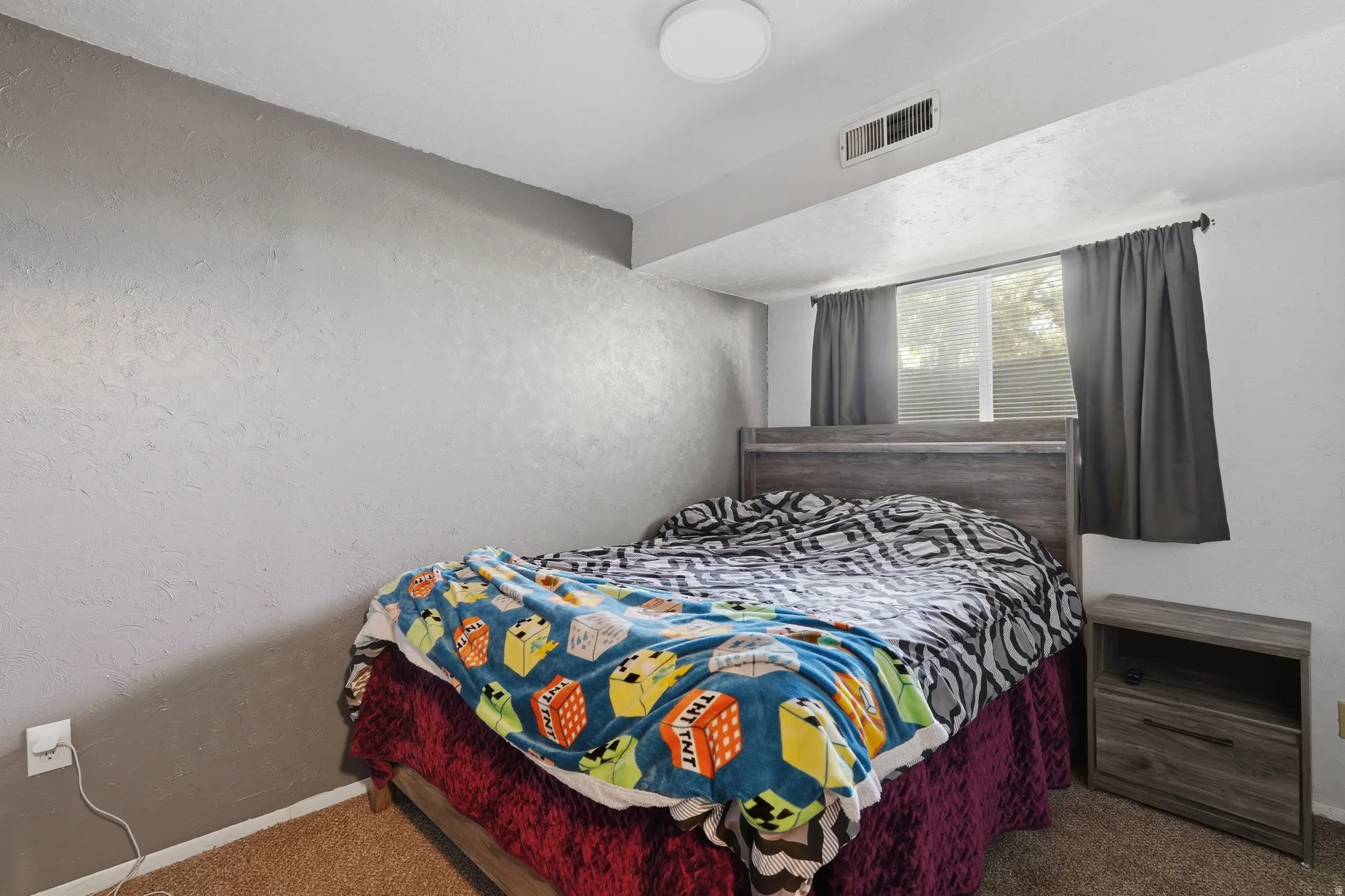 Bedroom featuring a built-in window and a textured accent wall