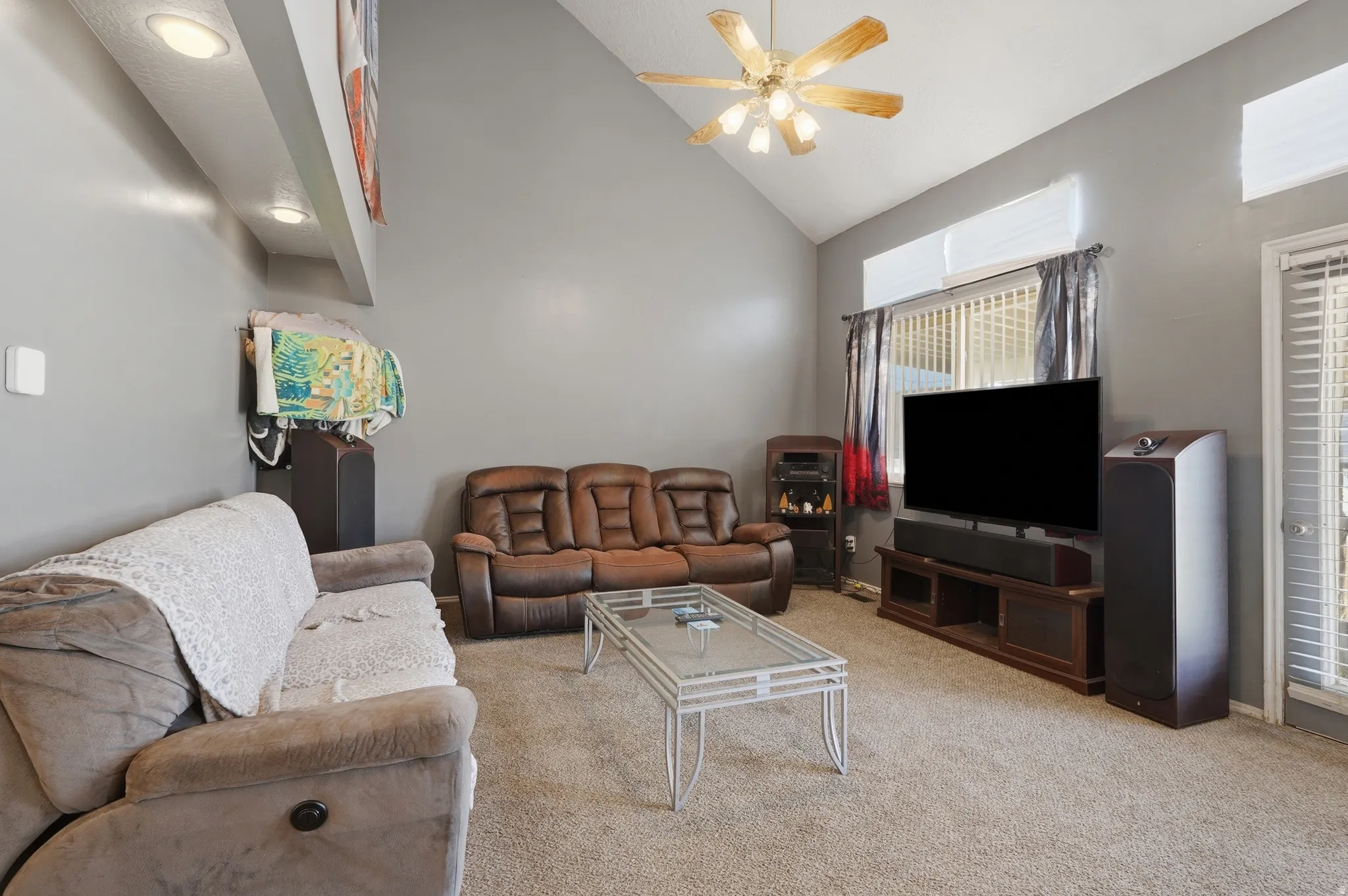Living area with vaulted ceiling, recessed lighting, and a ceiling fan