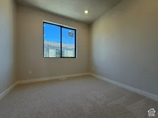 Neutral wall palette featuring carpeted flooring, recessed ceiling lighting, and a window with a dark-finished frame