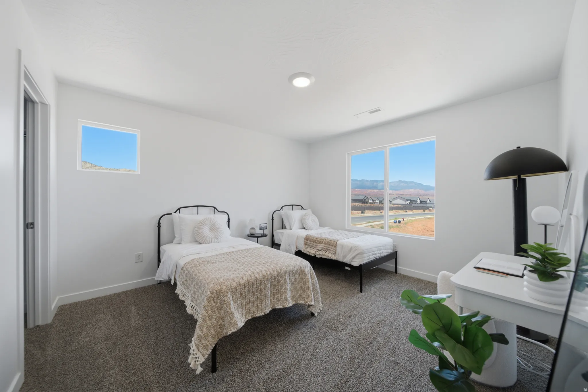 Spacious room featuring neutral carpeting, white walls, a large picture window, and a smaller horizontal window