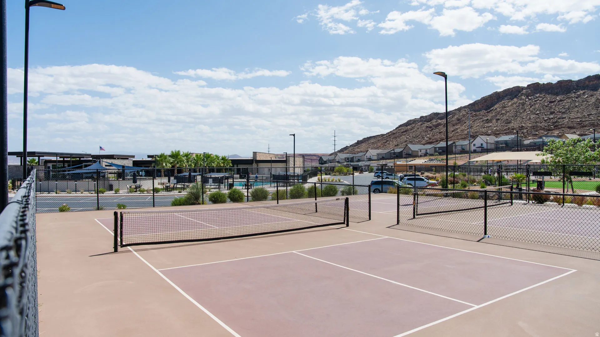 Outdoor pickleball courts featuring a hard-court surface and perimeter fencing