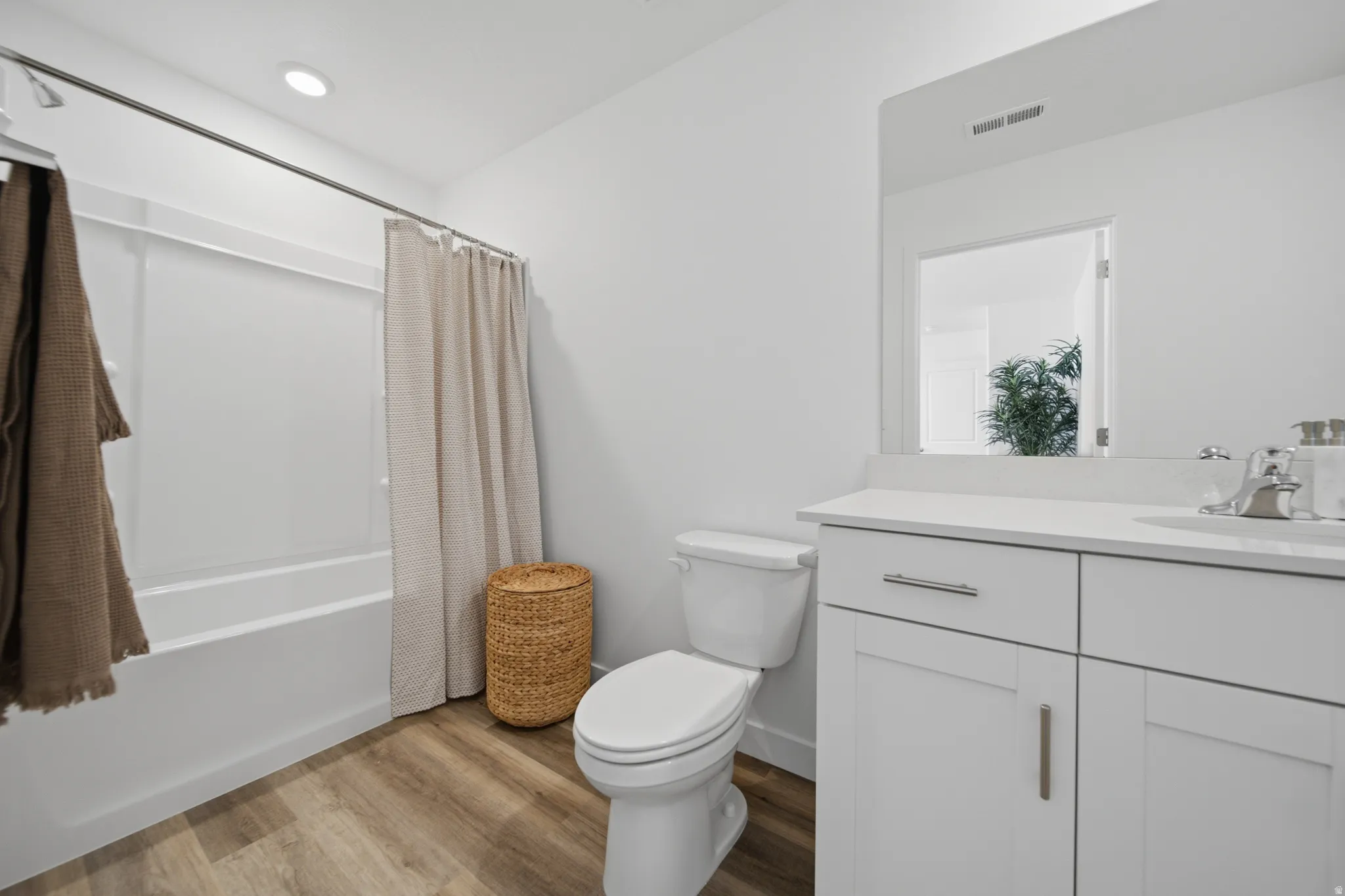 Spa-inspired primary bathroom featuring a white shaker-style vanity with dual drawers and chrome hardware, a white ceramic vessel sink, and a quartz countertop
