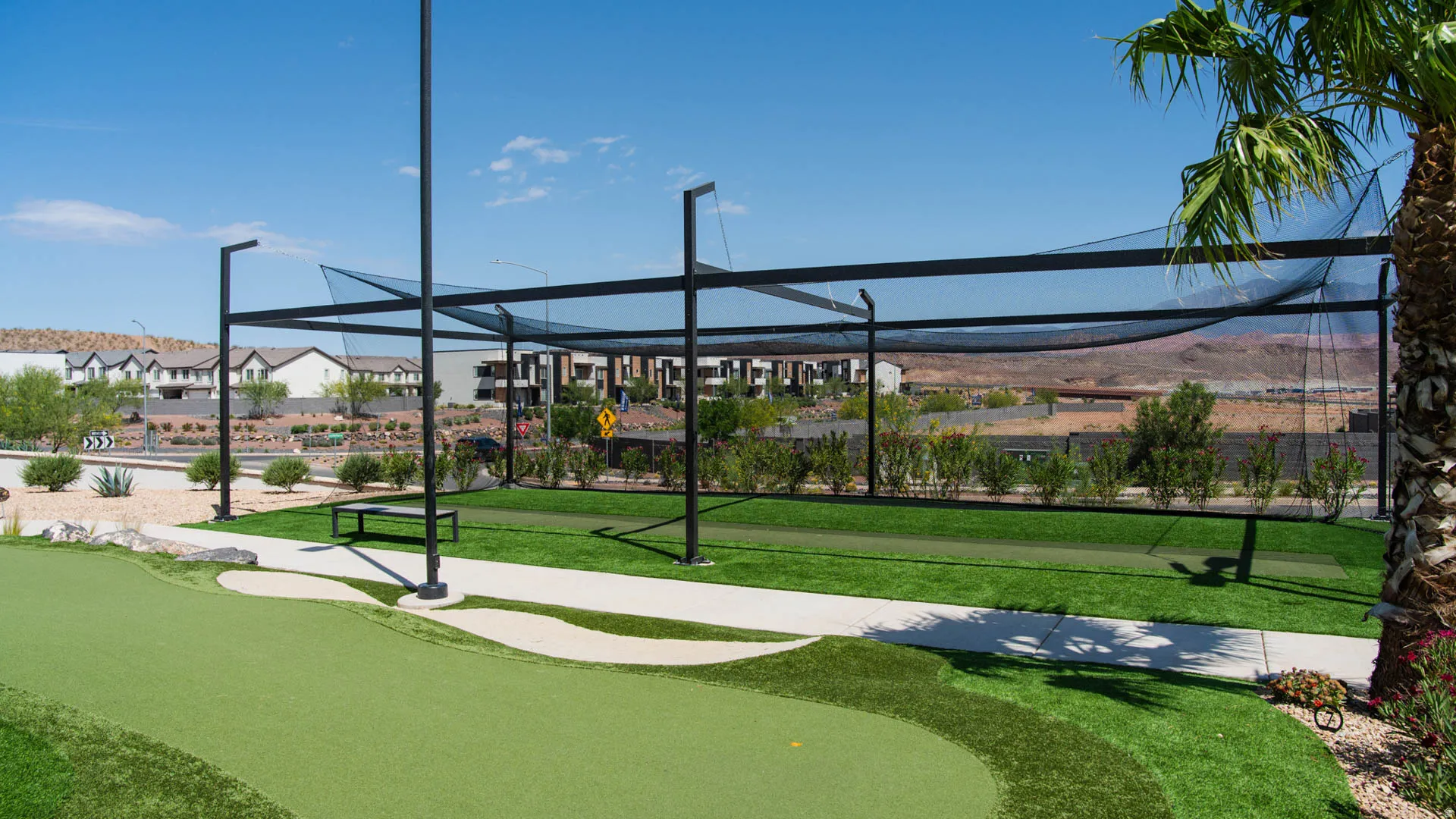 Expansive backyard oasis featuring manicured synthetic turf, a modern pergola structure with integrated overhead beams, and mature landscaping including palm trees