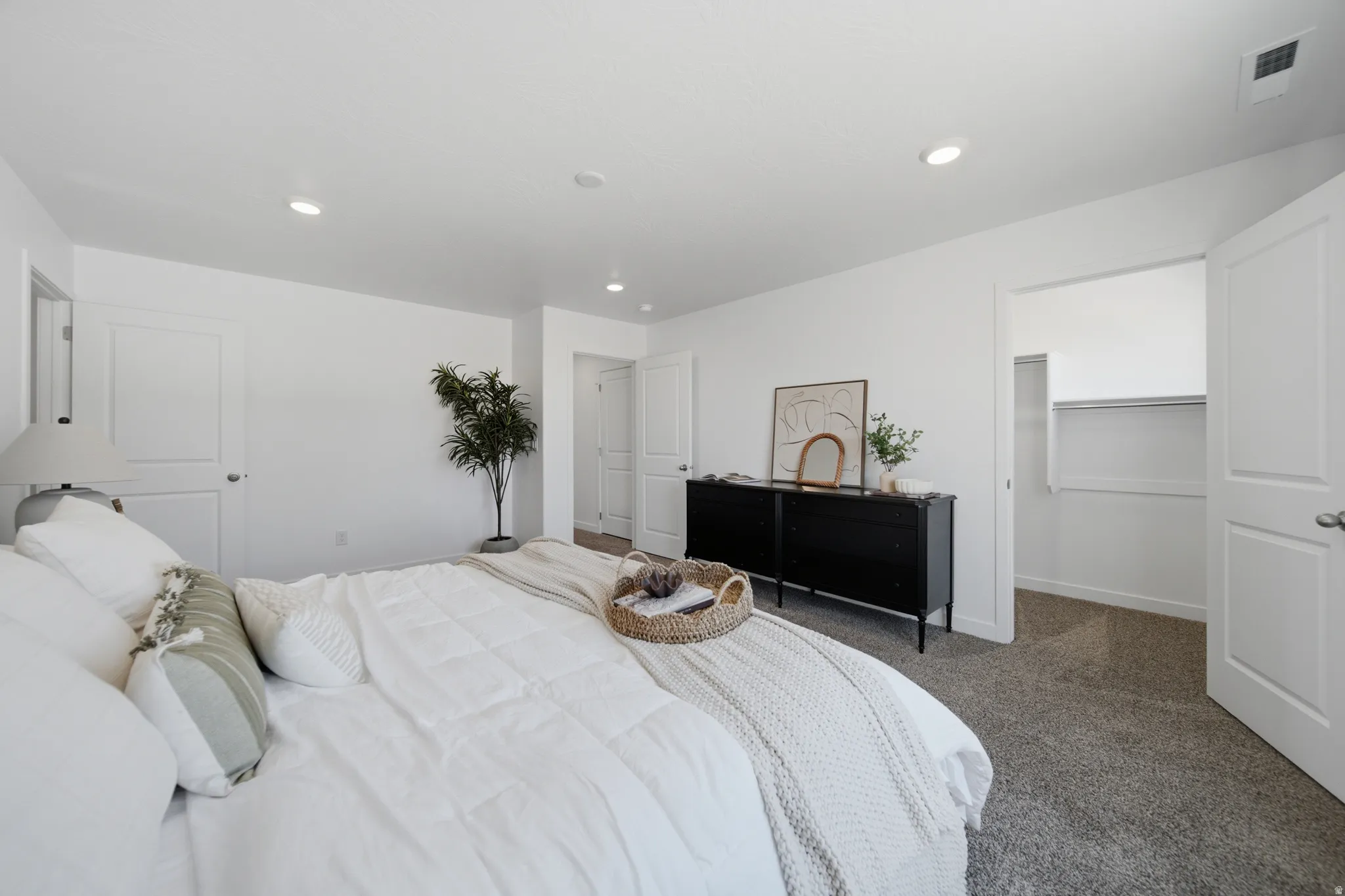 Spacious room with white walls, recessed lighting, and grey carpet flooring