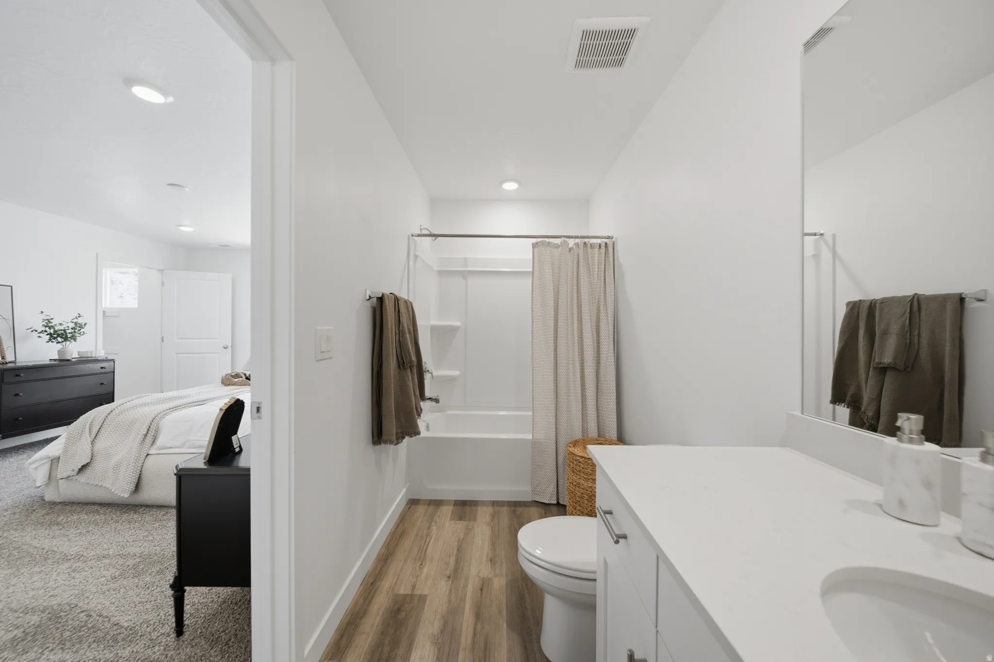White vanity with a single basin, complemented by a large mirror and matte black fixtures