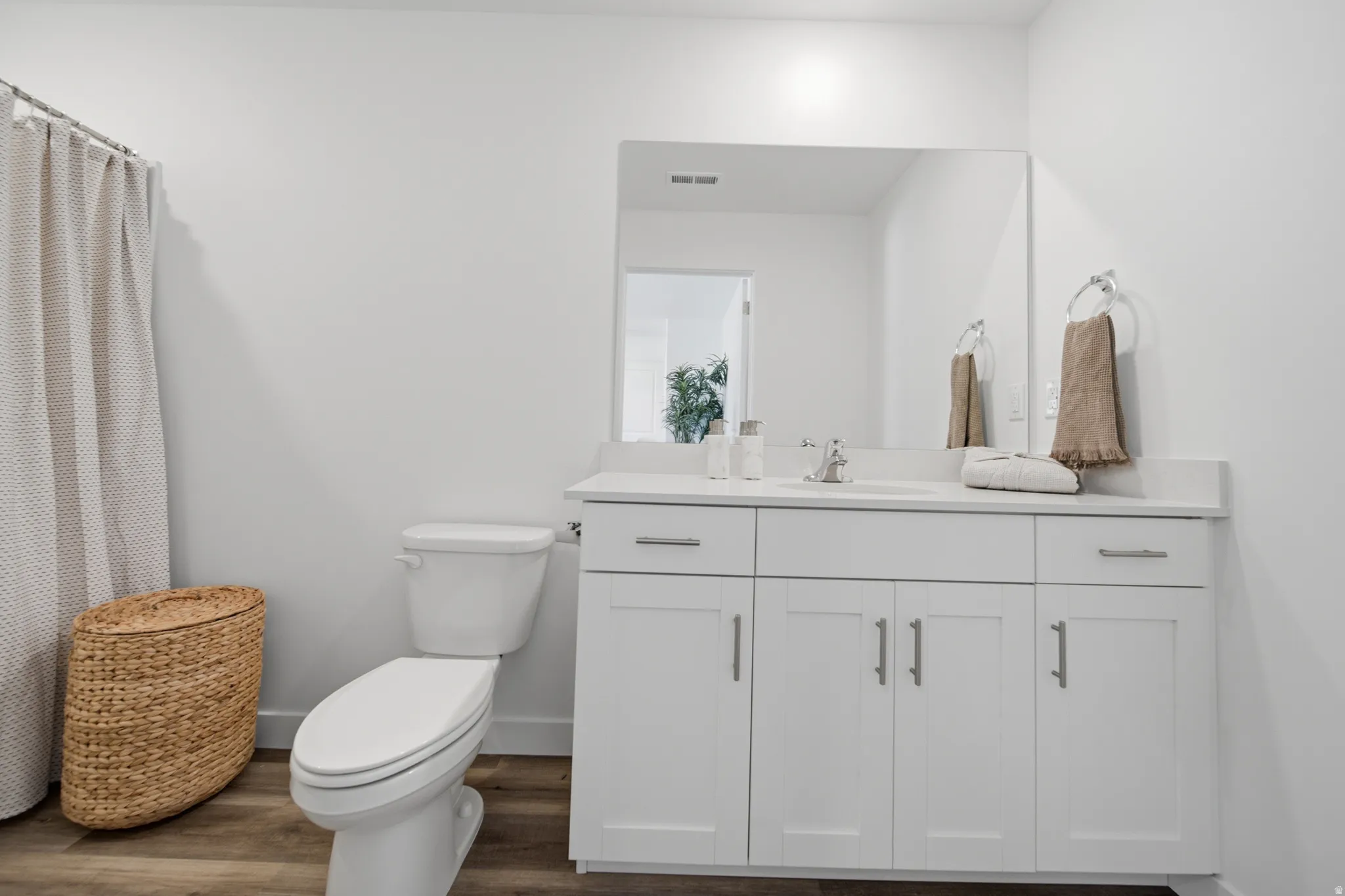 Bathroom featuring a white vanity with an integrated sink, polished chrome faucet, and a large wall-mounted mirror