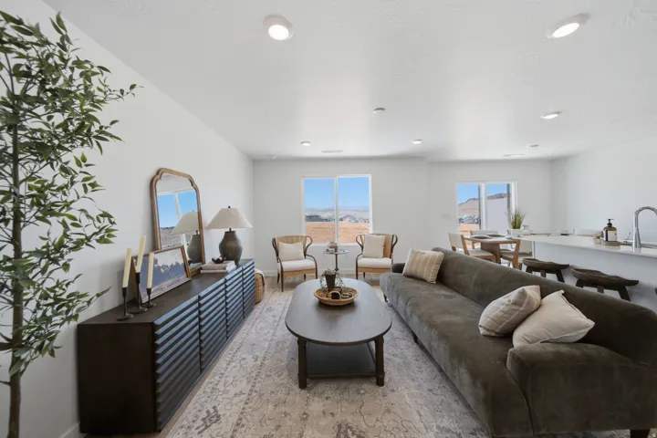 Open-concept living area featuring recessed lighting, large windows, and light-toned walls