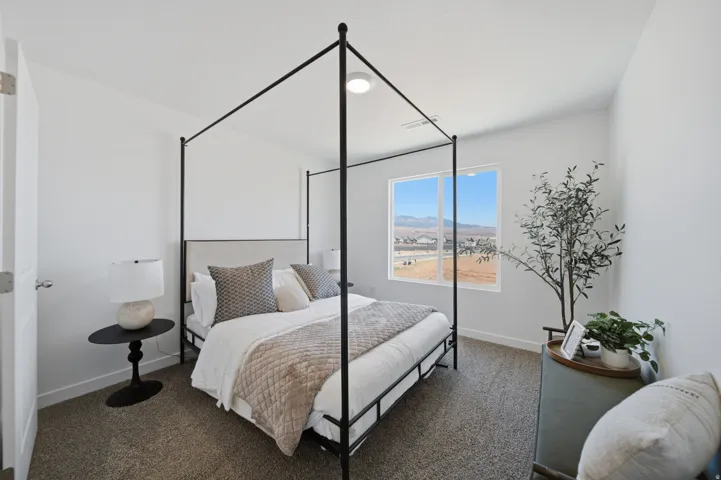 Spacious interior room featuring a large window, neutral wall paint, and textured carpeting