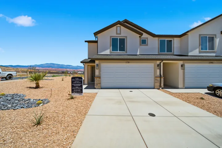Modern stucco exterior with stone accents and a two-car garage