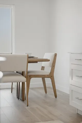 Dining area featuring light wood-finish flooring and a white window frame