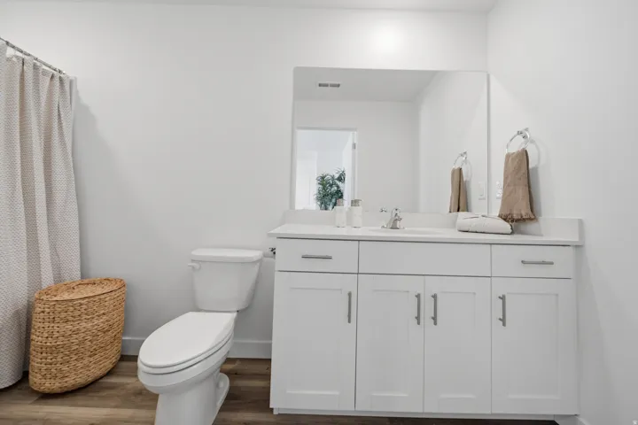 Bathroom featuring a white vanity with an integrated sink, polished chrome faucet, and a large wall-mounted mirror