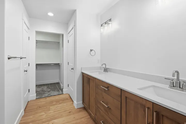Double vanity featuring white countertops and wood-finish cabinetry
