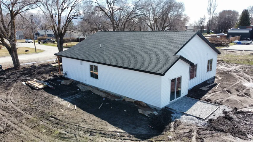 Newly constructed residence featuring white siding, a dark shingle roof, and black exterior trim