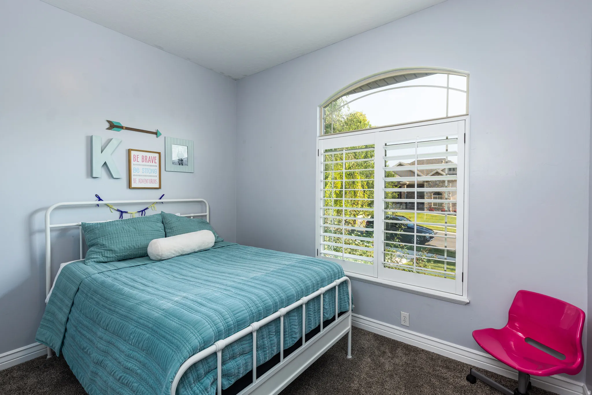Arched window with plantation shutters, featuring a white trim