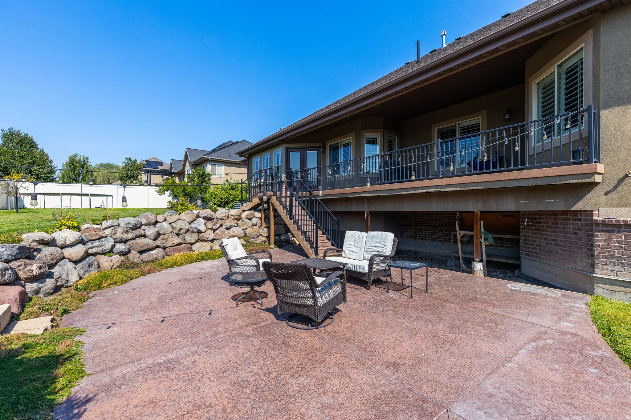 Stamped concrete patio with stone retaining wall