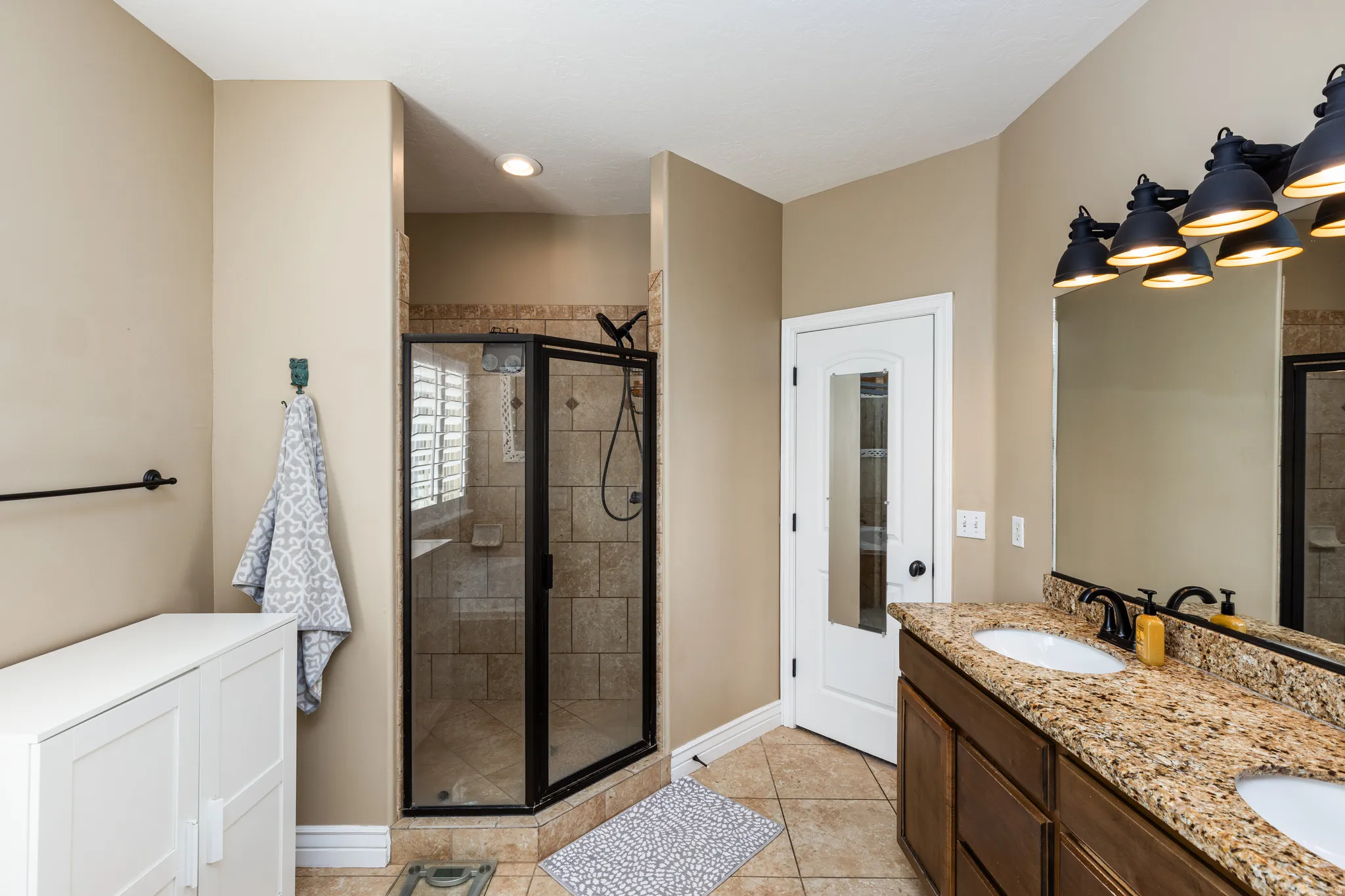 Bathroom featuring a corner glass-enclosed shower with tile surround and built-in bench