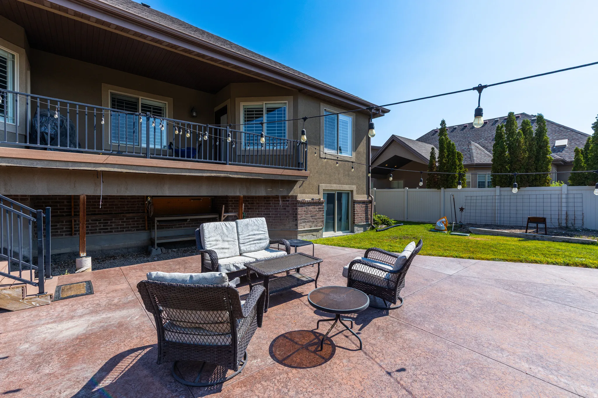 Stained concrete patio with a spacious upper deck featuring black metal railings