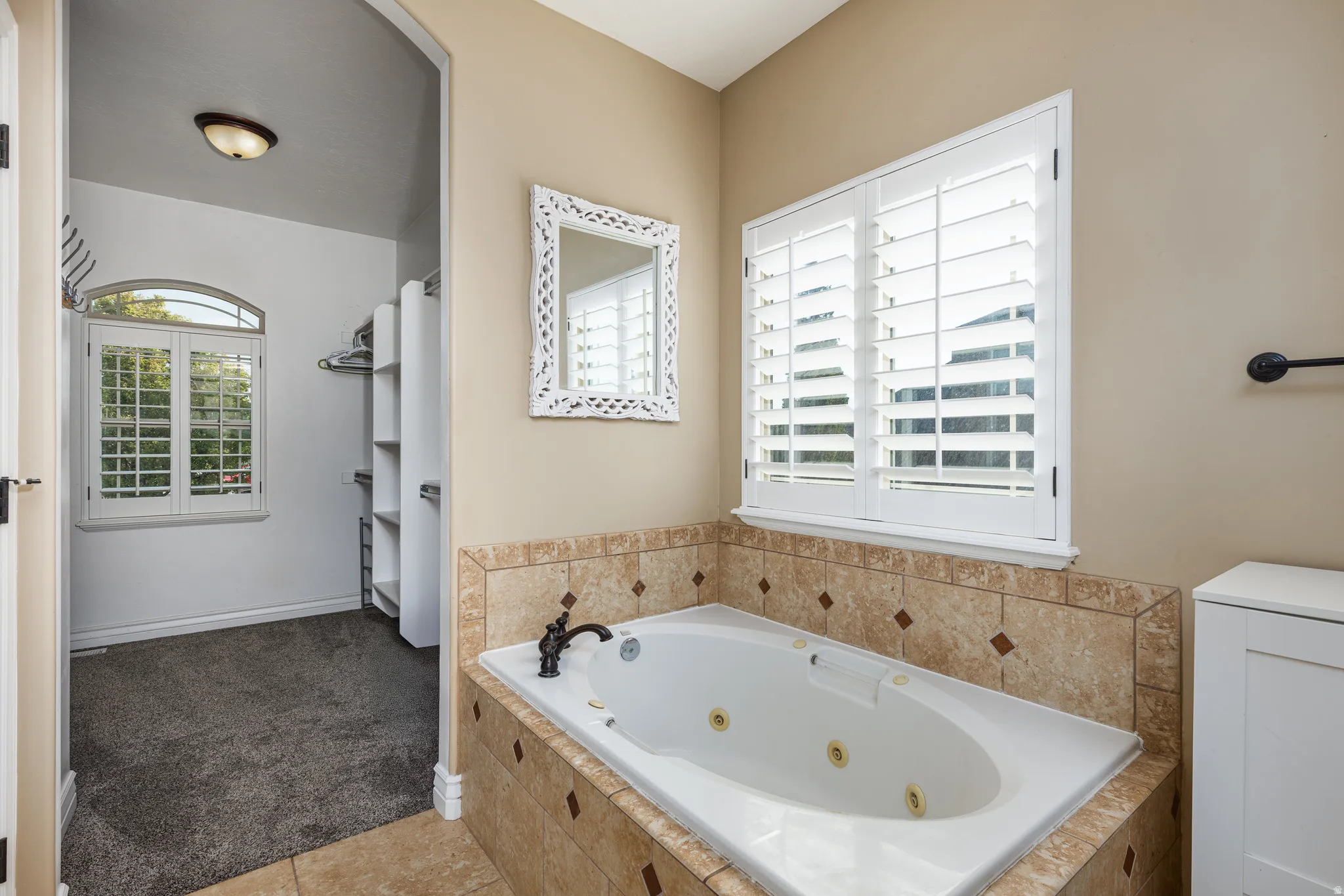 Soaking tub with jetted features, surrounded by tiled decking and wall accents