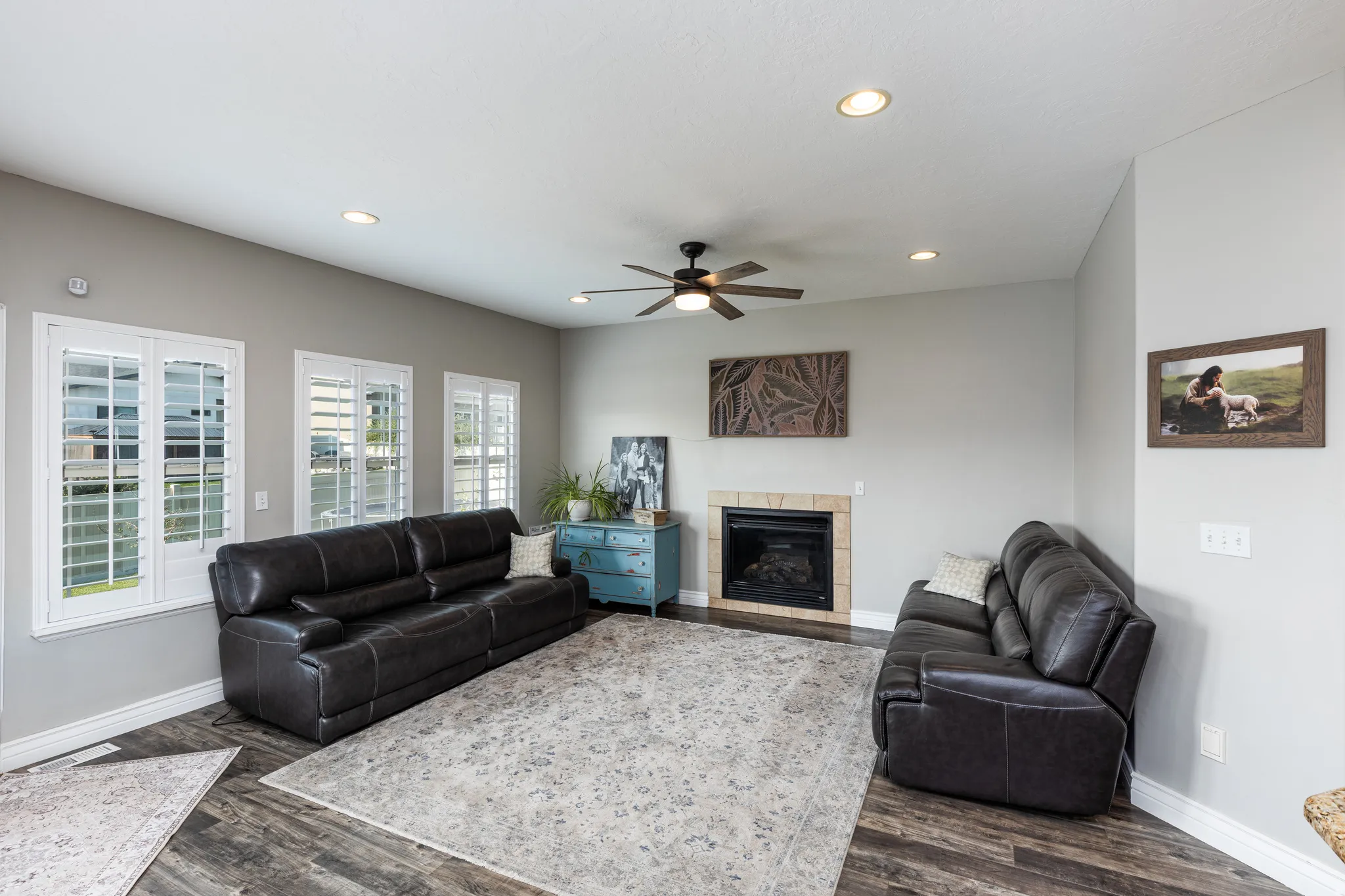 Spacious living area featuring wood-finish flooring, a ceiling fan, and recessed lighting