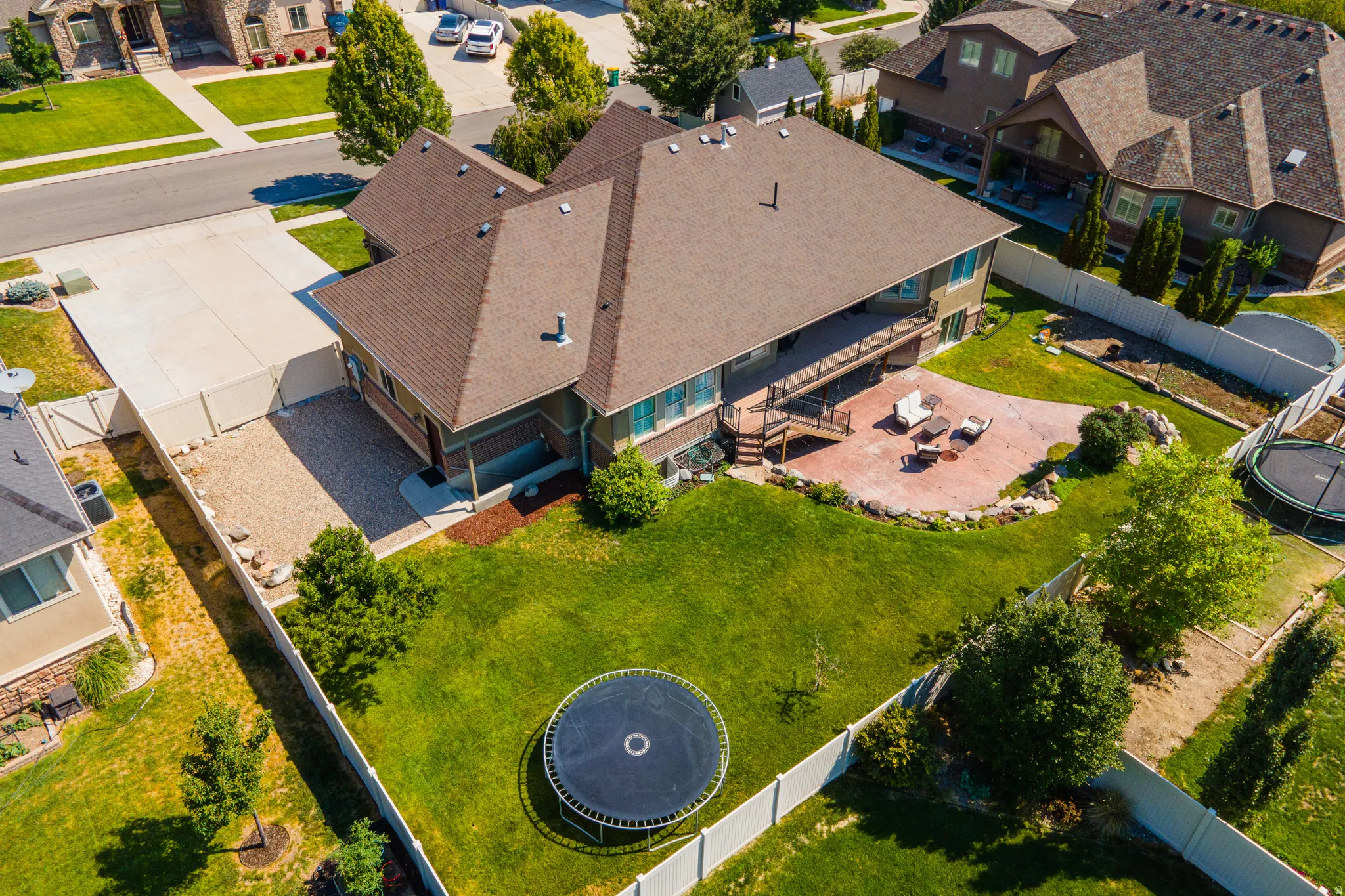 Expansive backyard featuring a large patio, terraced landscaping, and a spacious deck