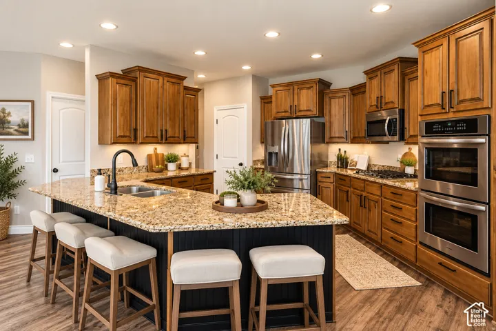 Wood-finish flooring with a large island featuring a double-basin sink and a matte black faucet