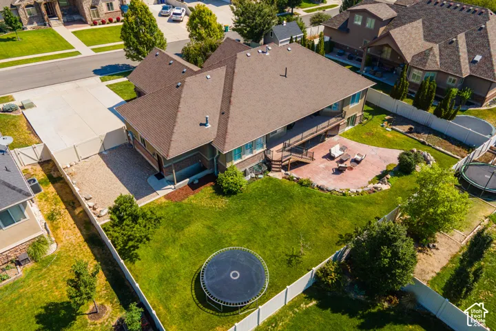 Expansive backyard featuring a large patio, terraced landscaping, and a spacious deck