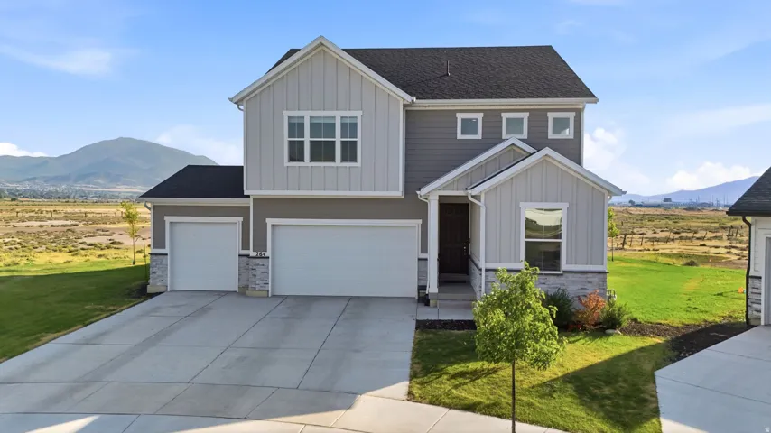 Contemporary two-story residence featuring a two-tone siding exterior and stone accents
