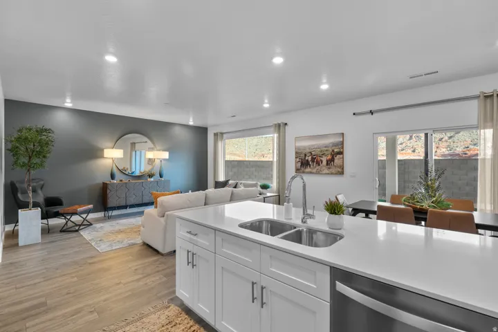 Kitchen island with dual stainless steel sink, white cabinetry, and a light-toned countertop