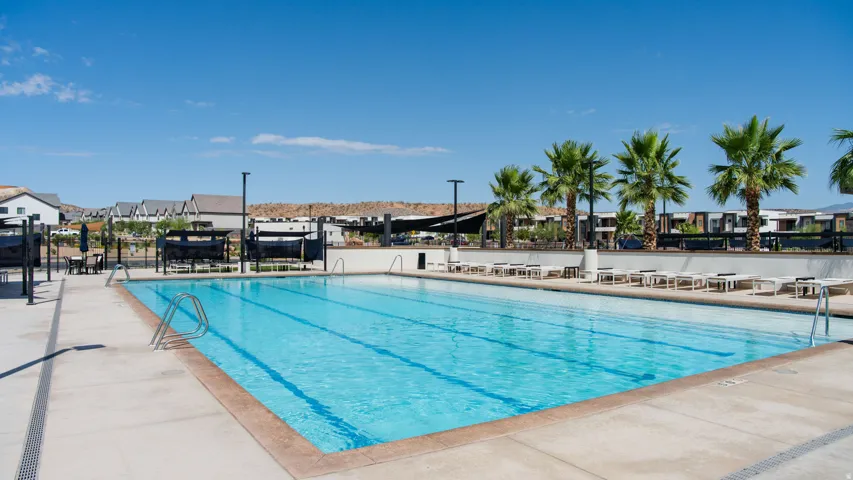 Resort-style Olympic-length lap pool featuring crystal-clear water, multiple lane markings, and surrounding concrete decking
