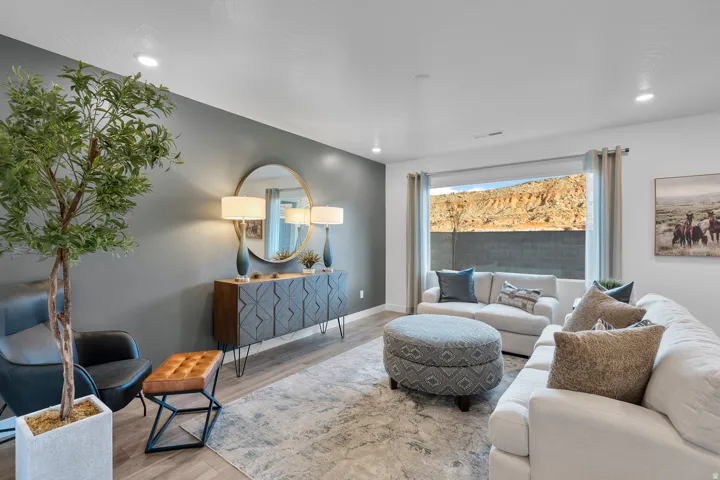 Spacious living area featuring a large window, recessed lighting, wood-finish flooring, and a neutral color palette