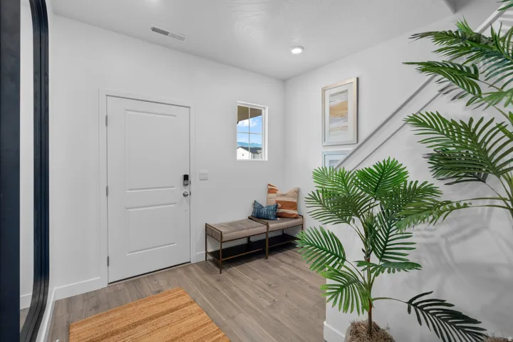 Entryway featuring wood-finish flooring, a white paneled door with smart lock, recessed lighting, and a square window