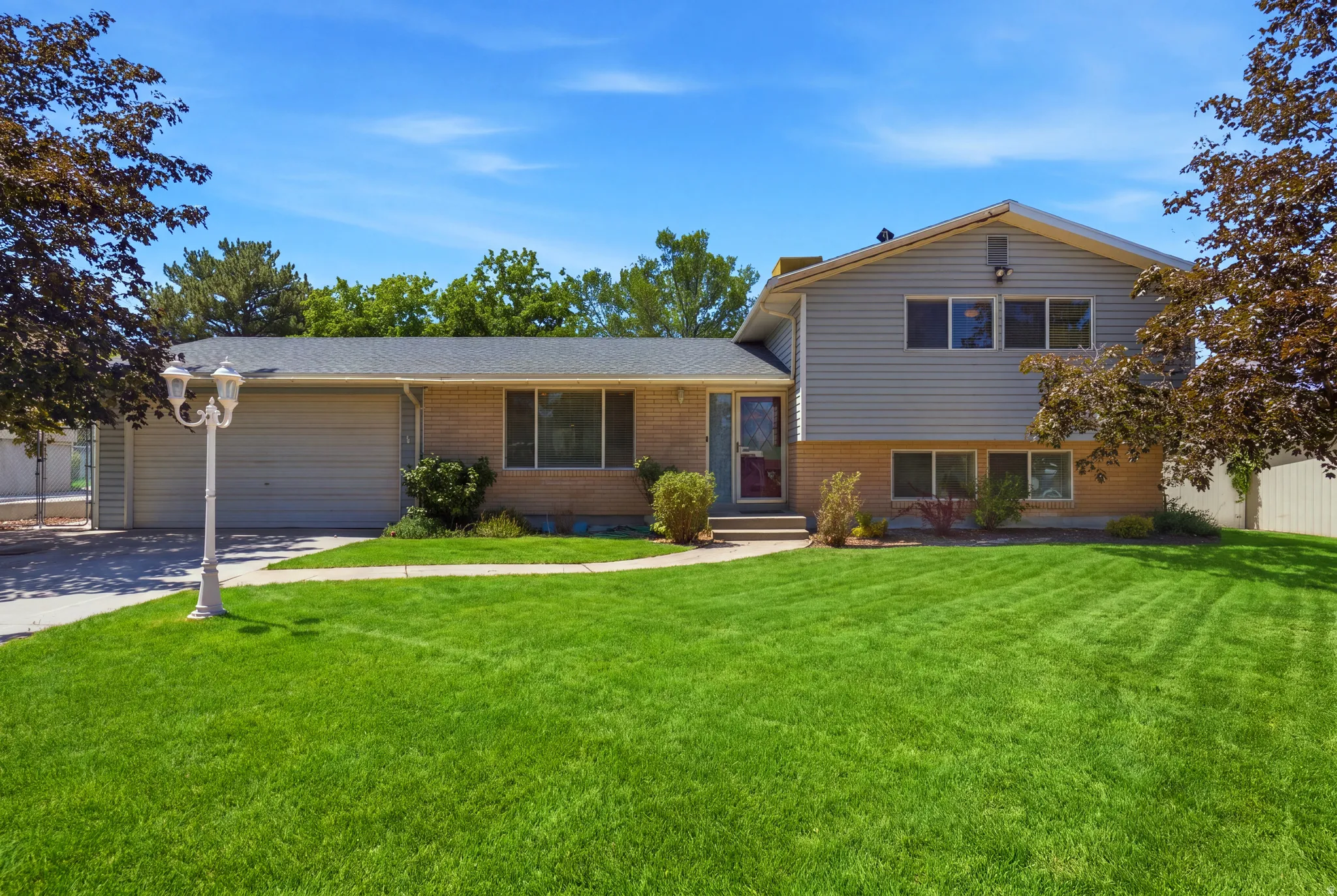 Grass has been virtually enhanced in this image to illustrate the property's outdoor potential. Split-level residence featuring a brick and siding exterior