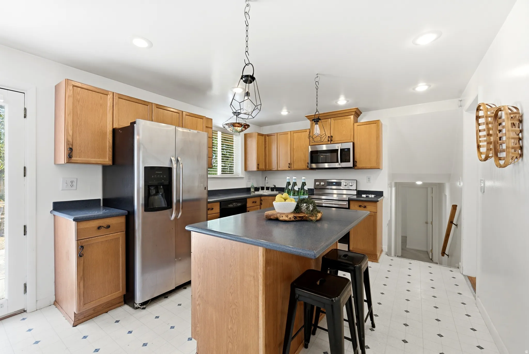 Kitchen featuring natural wood-finish cabinetry, dark countertops, and newer stainless steel appliances