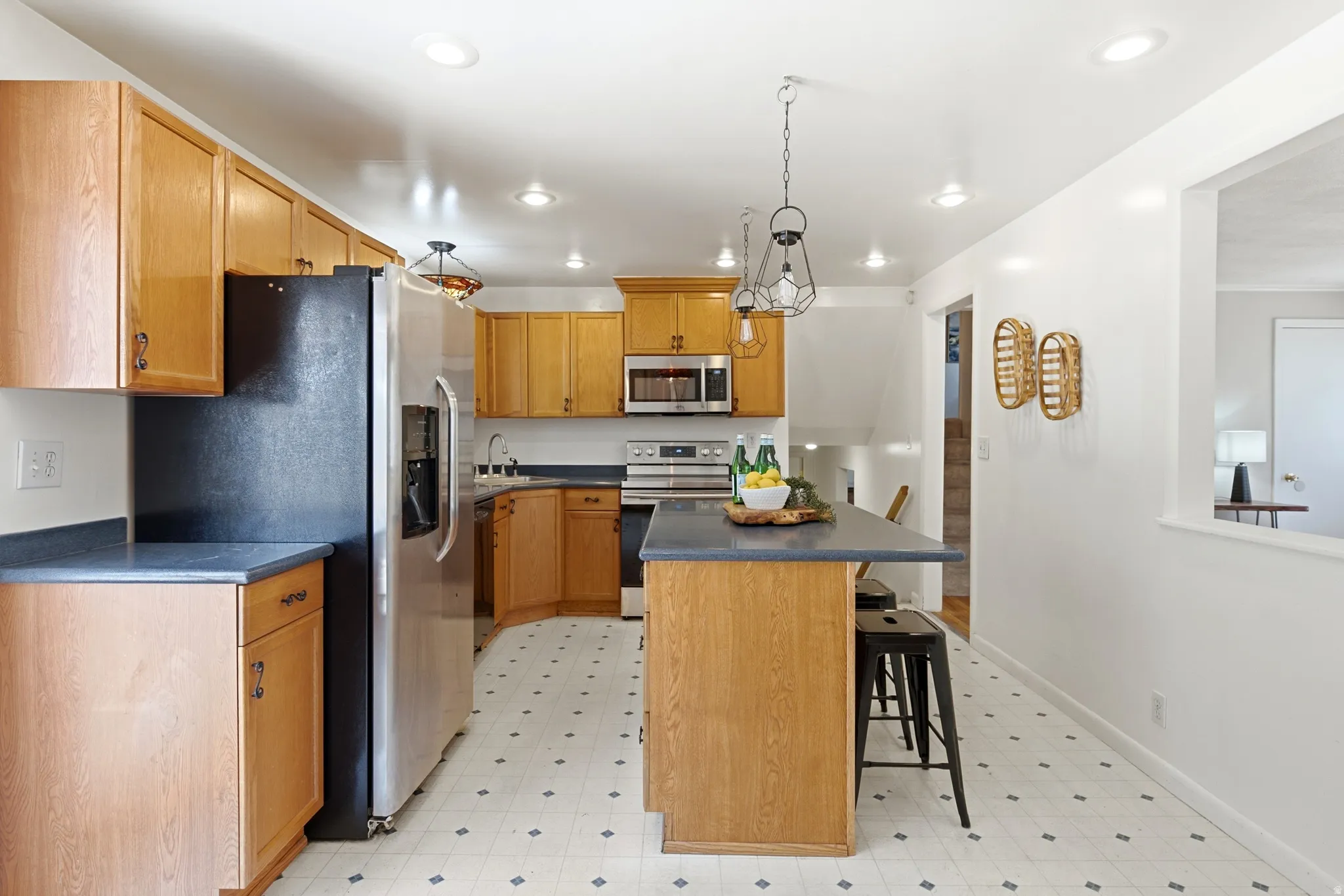 Kitchen featuring light wood cabinetry and dark countertops